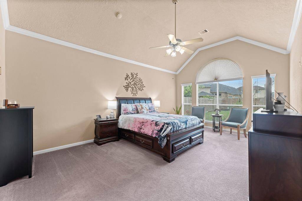 First-floor primary bedroom with large windows overlooking the backyard