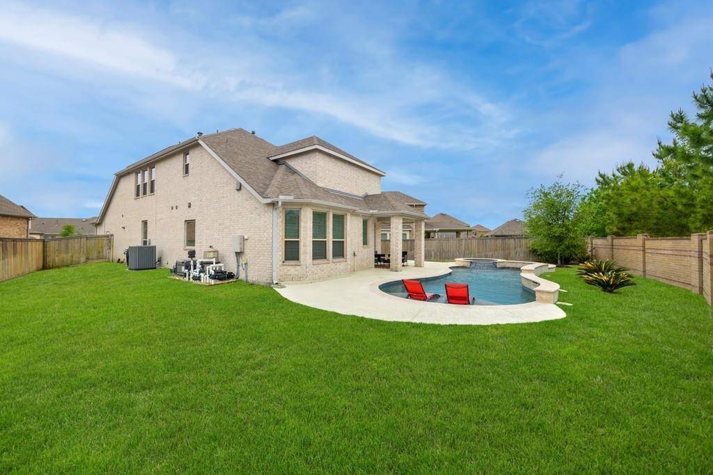 The crown jewel of this house is the magnificent outdoor living space featuring a custom pool and spa with a raised wall and spectacular water features for a full day of fun  in the sun - Accompanied, of course by the covered patio with extended sunny seating space in your private fenced backyard with lots of grassy area left over to enjoy a lawn game or playing fetch with your pet!