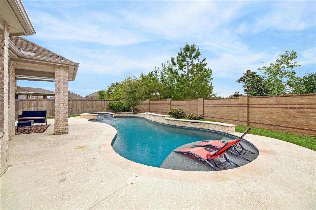 The crown jewel of this house is the magnificent outdoor living space featuring a custom pool and spa with a raised wall and spectacular water features for a full day of fun  in the sun - Accompanied, of course by the covered patio with extended sunny seating space in your private fenced backyard with lots of grassy area left over to enjoy a lawn game or playing fetch with your pet!