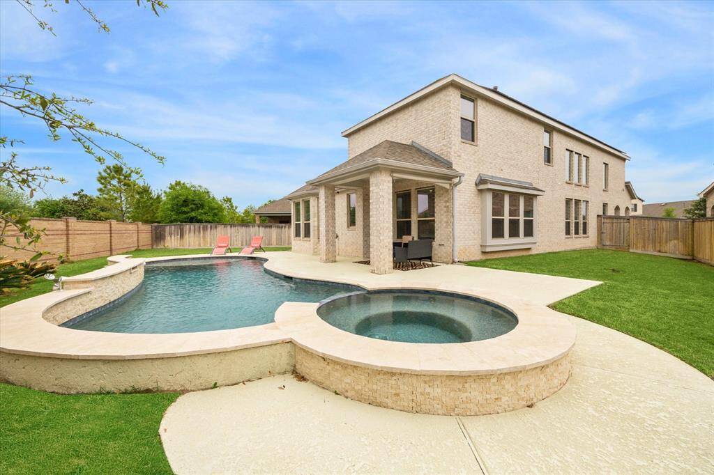 The crown jewel of this house is the magnificent outdoor living space featuring a custom pool and spa with a raised wall and spectacular water features for a full day of fun  in the sun - Accompanied, of course by the covered patio with extended sunny seating space in your private fenced backyard with lots of grassy area left over to enjoy a lawn game or playing fetch with your pet!