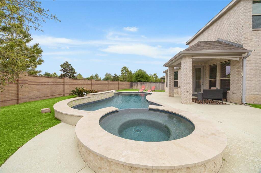 The crown jewel of this house is the magnificent outdoor living space featuring a custom pool and spa with a raised wall and spectacular water features for a full day of fun  in the sun - Accompanied, of course by the covered patio with extended sunny seating space in your private fenced backyard with lots of grassy area left over to enjoy a lawn game or playing fetch with your pet!