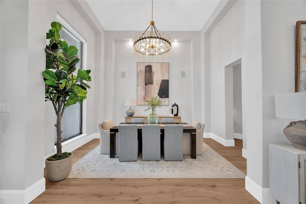 A formal dining room with soaring ceiling and a custom chandelier.