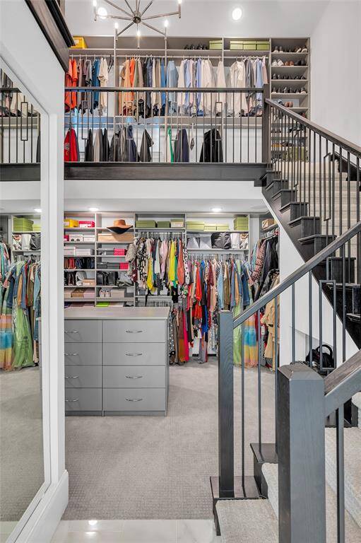 Incredible 2-story primary closet with built-in center island featuring extra drawer space.
