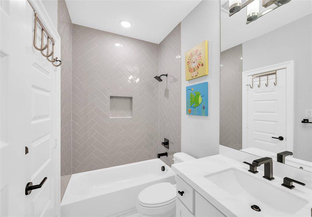 Fourth bedroom ensuite bath with upgraded herringbone tile surround.