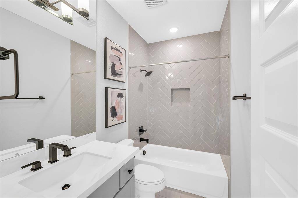 Fifth bedroom ensuite bath, featuring porcelain countertop and upgraded herringbone tile surround.