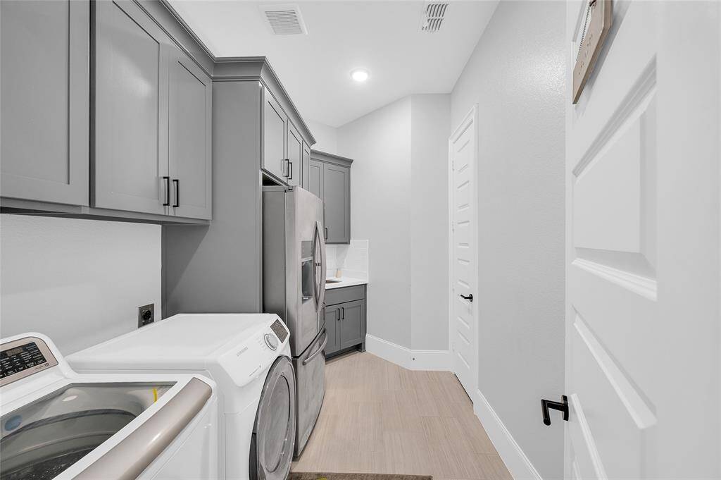 The main floor laundry room features a utility sink and custom cabinetry. The refrigerator will be included.