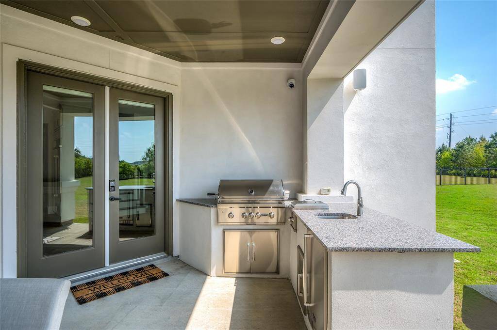 Outdoor kitchen with 36" SS Coyote grill and a mini fridge.