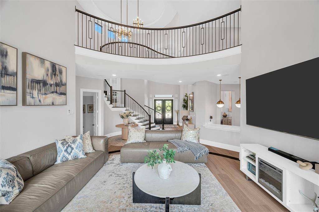 View from 2-story the elevated living room into the foyer, butler's pantry, and second level catwalk.