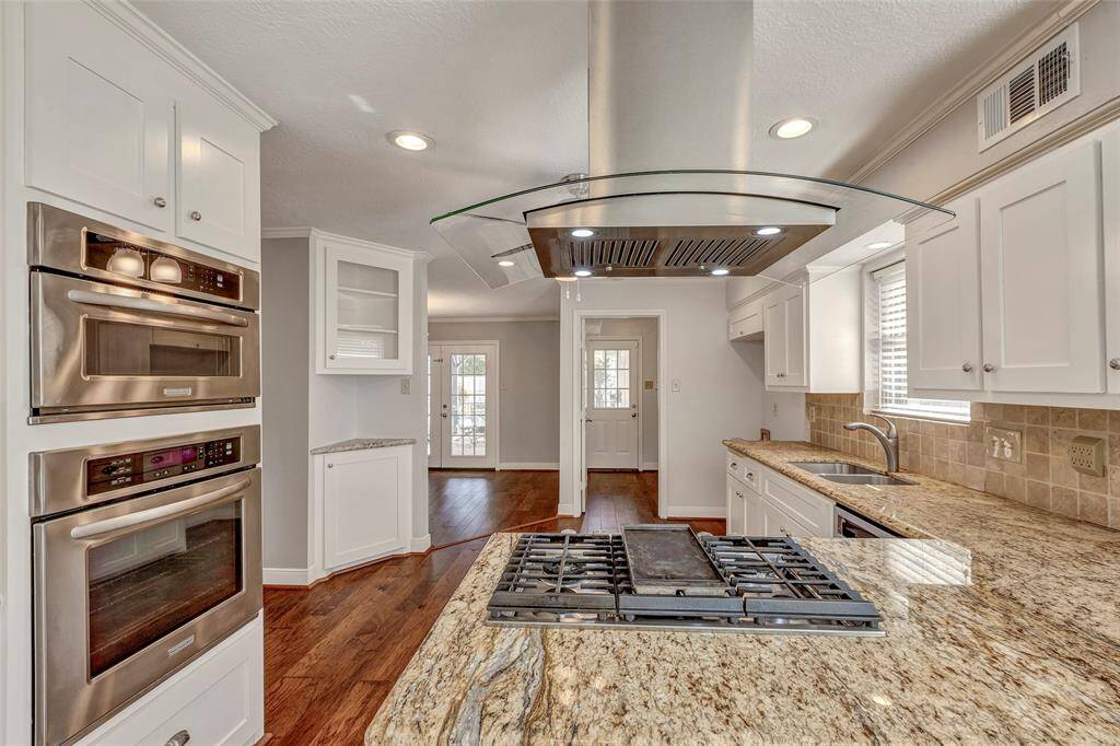 Chefs gas cooktop with stainless vent hood.
