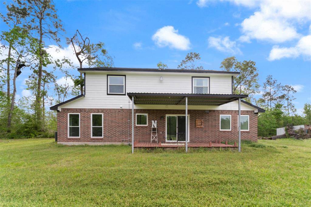 Spacious backyard surrounded by trees. Ideal for outdoor relaxation and entertaining.
