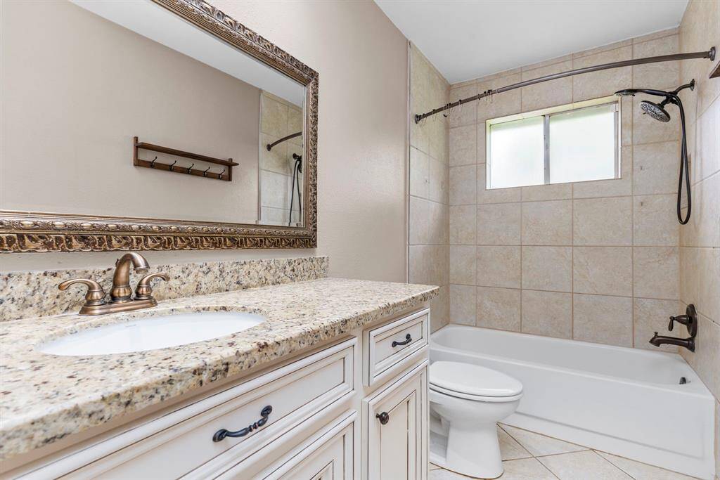 The guest bathroom boasts granite countertops, custom vanity and tub with shower combination!