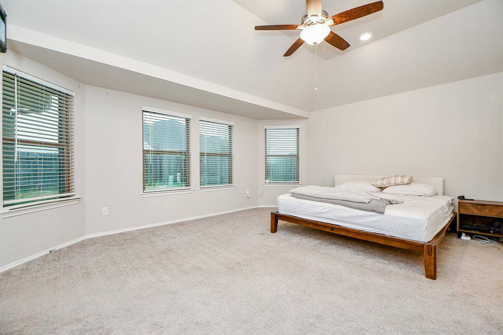 The primary bedroom is a spacious and tranquil retreat, designed for ultimate comfort and relaxation. With large windows allowing for plenty of natural light, the room exudes warmth and openness.