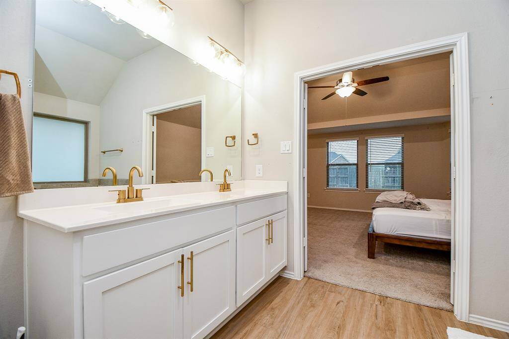 Dual vanities with ample counter space and stylish cabinetry offer both convenience and storage.