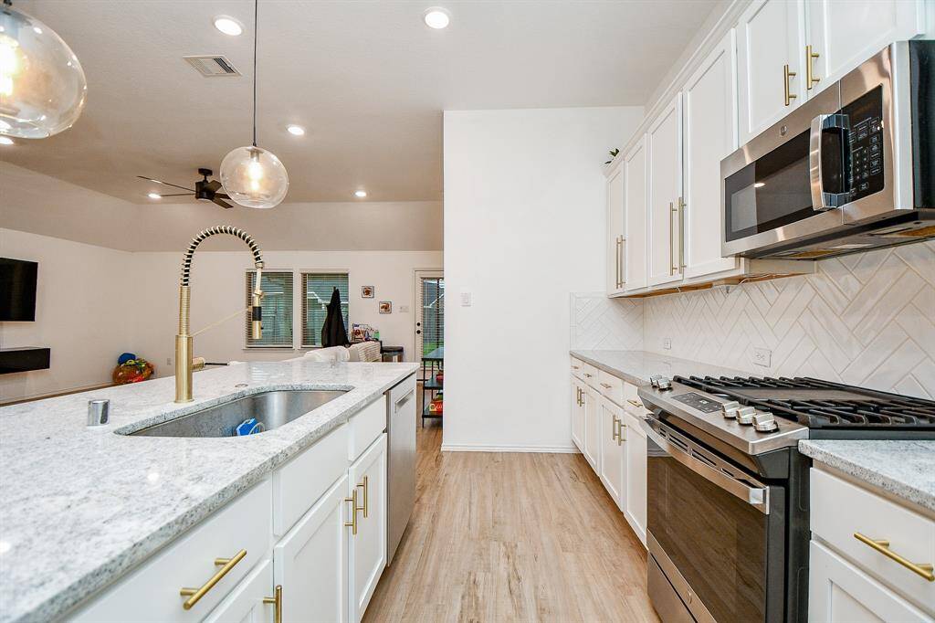The centerpiece is the oversized kitchen island, offering plenty of room for food prep, casual dining, or gatherings.