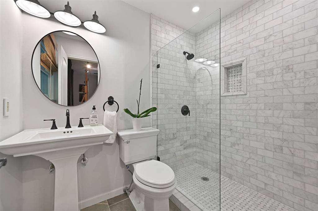 Off of the garage with an exit to the backyard and pool, the art studio features tile flooring and custom track lighting. This room also features its own en-suite bathroom and would make a great guest room, pool room, play room, etc. Imagine the possibilities!