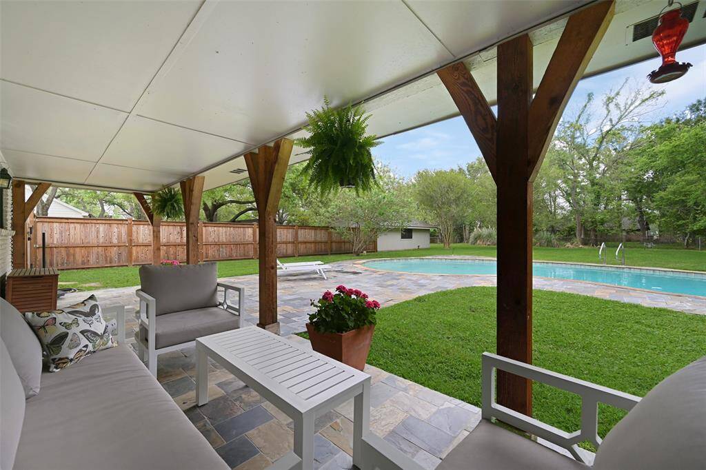 Step outside to your flagstone covered patio with custom wooden pillars- the perfect place to relax in your amazing backyard!