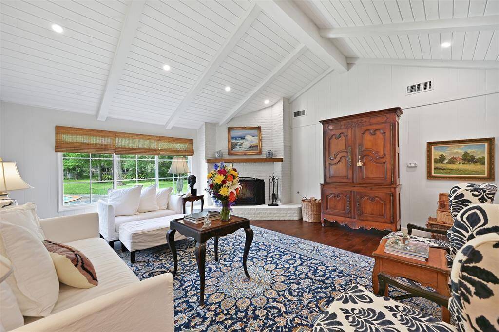 Your oversized living room showcases vaulted ceilings, wooden beams, and a lime-washed fireplace.
