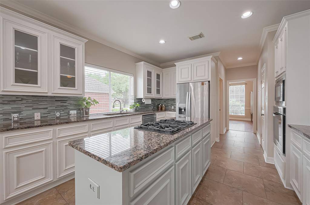 Refreshed kitchen features granite counter tops and island with 4 burner gas stove