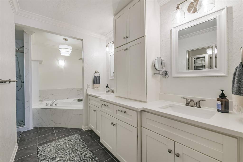 Heading into the primary bathroom we see the double sinks and the luxurious soaking tub.