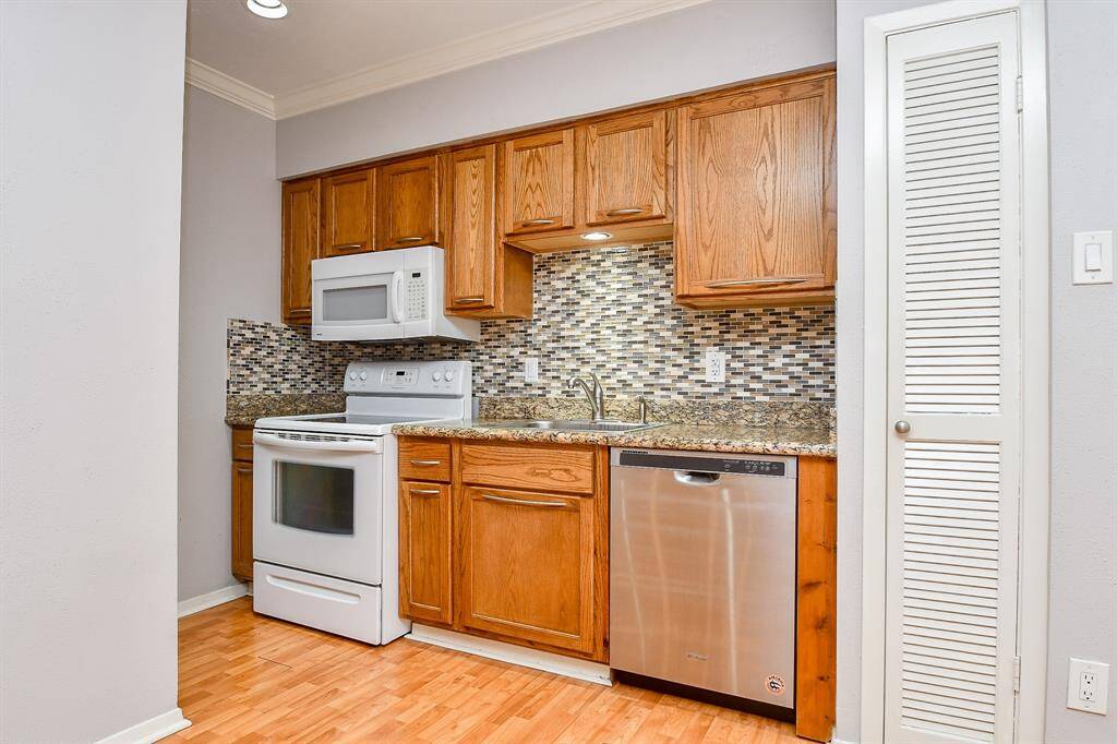 Another view of the well designed kitchen space.  The stainless refrigerator/freezer combination is directly across from the oven/stove top combination.