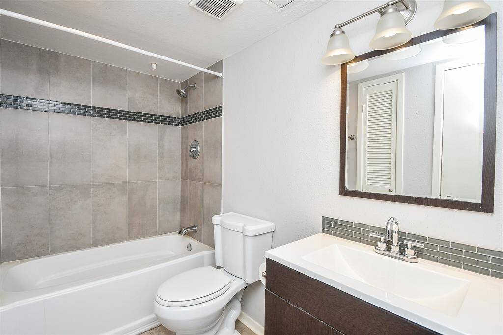 The remodeled bath has an oversized tiled bath/shower combination and a beautiful vanity and sink area.