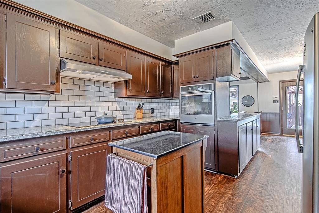 Additional view of the kitchen featuring a built-in oven, sleek granite countertops, and easy access to the dining room for convenient meal service.