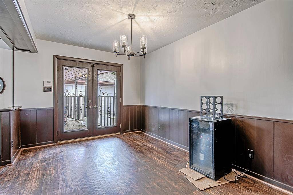 Bright dining room with stylish French doors leading to the backyard, offering easy access to the garage through a convenient covered walkway.