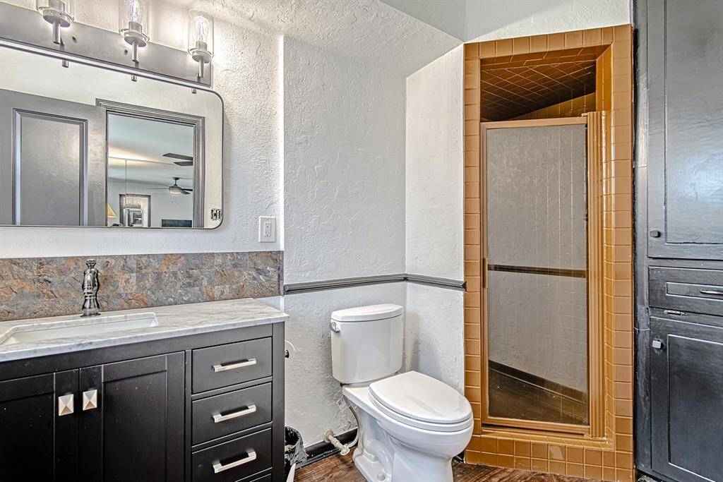 Primary ensuite features a spacious tiled walk-in shower and a built-in linen and laundry cabinet for convenient storage.