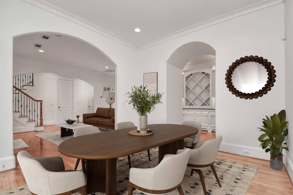 Virtually Staged Photo:Step inside to the foyer to be greeted by gleaming hardwood floors & arched entryways. Formal living room with gas fireplace, providing access to the formal dining room.