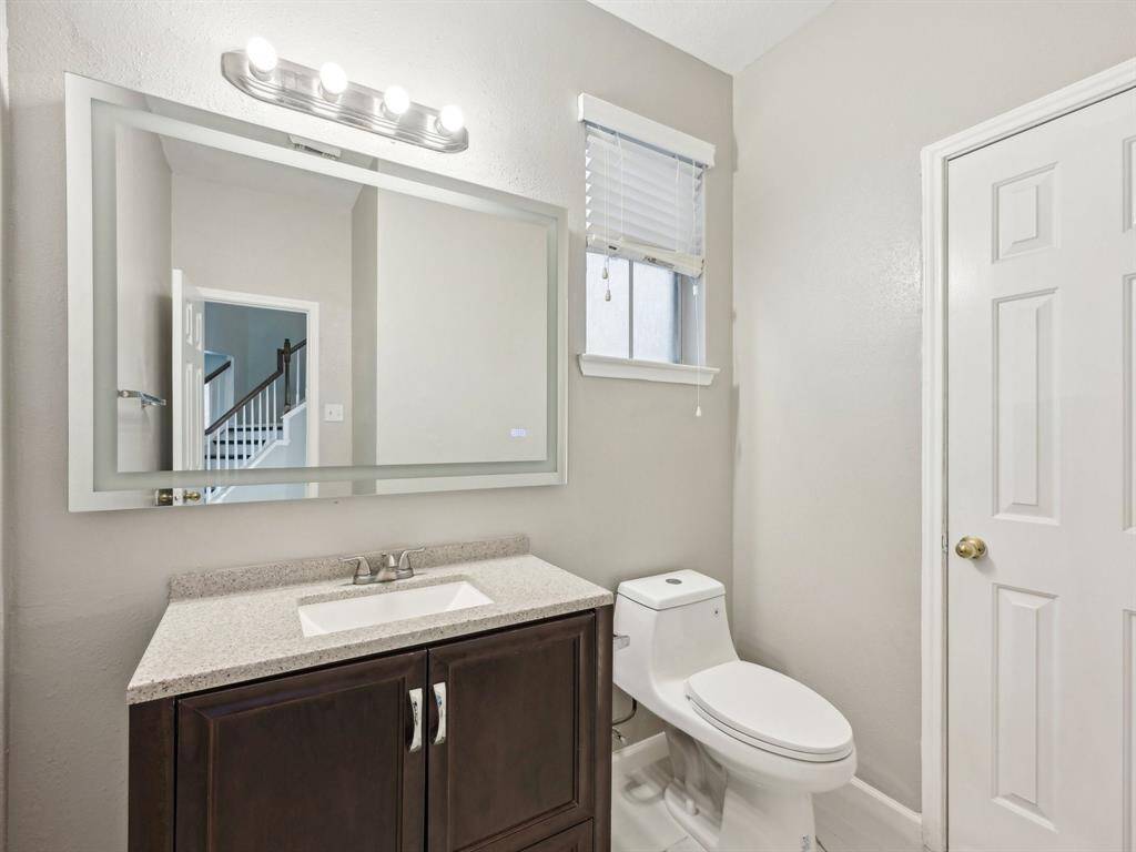 This half bath has been updated and even features a cool lighted mirror so your guests can touch up their makeup and what not.