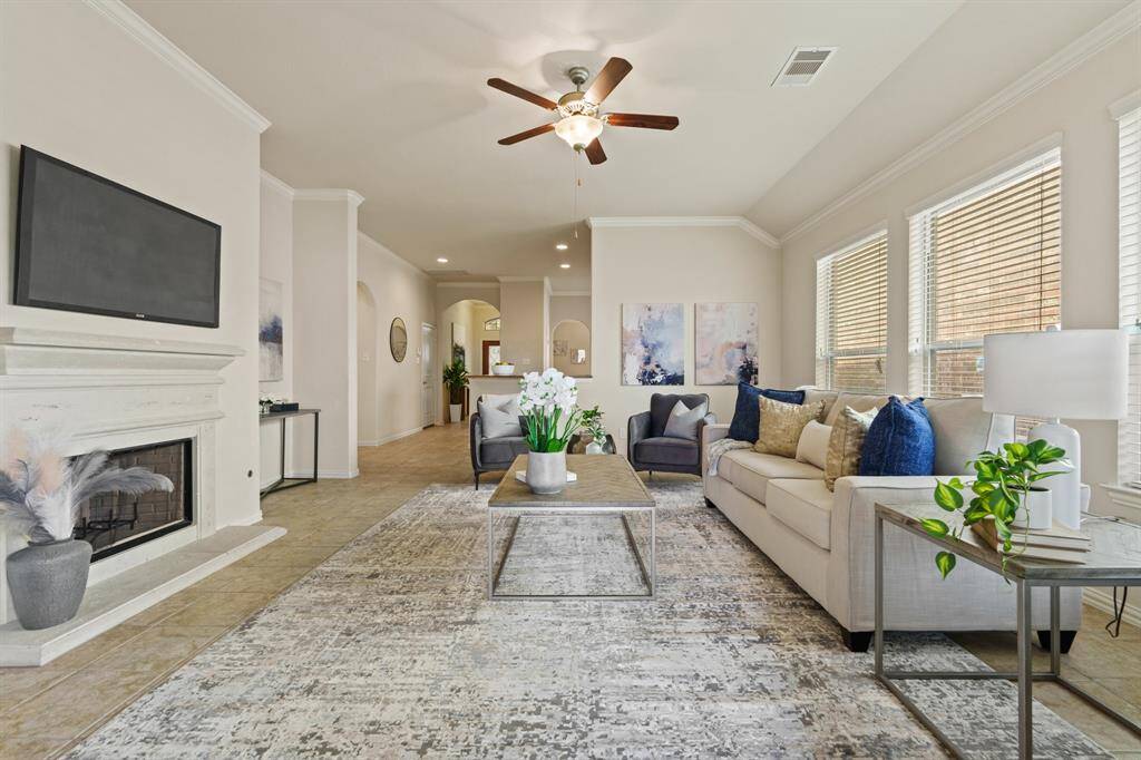 Brimming with natural light, this bright and airy family room invites you to slow down and stay awhile, with soaring ceilings, elegant crown molding, and a cozy fireplace setting the tone for easy everyday living and effortless entertaining.