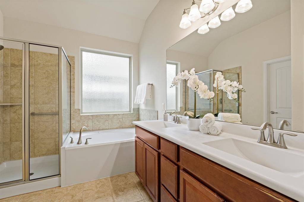 You’ll find everything you need to prepare for the day’s adventures in this immaculate ensuite. The dual-sink vanity features a sleek solid-surface countertop with smooth under-mount sinks, a full-width mirror, and stylish lighting above. Unwind in the luxurious jetted tub or refresh in the separate walk-in shower. This space is all about comfort and convenience.