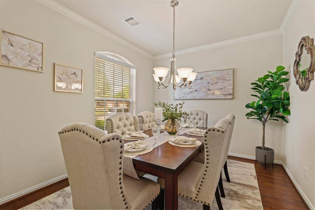 Your friends and family will love breaking bread with you in this elegant formal dining room, featuring stunning hardwood flooring, neutral paint, crown molding, and a stylish chandelier.