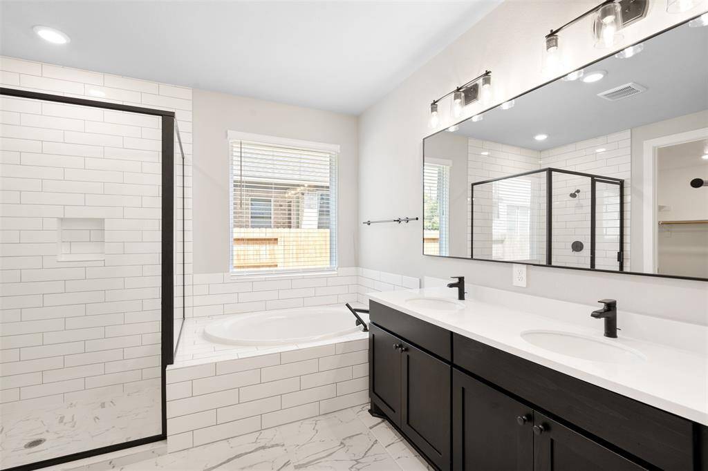 Primary bathroom with separate show and soaking tub. Double vanity sink and large walk in closet