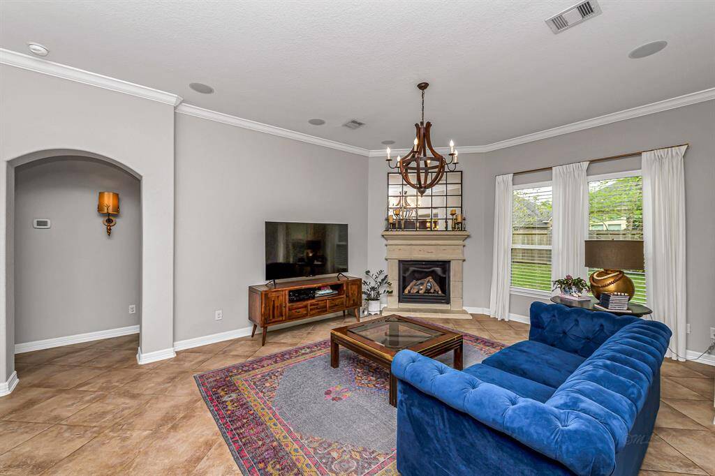 The primary bedroom is generously sized with gorgeous tile flooring and a wall of windows with custom blinds for soft, natural light. A peaceful retreat tucked away for privacy and rest.