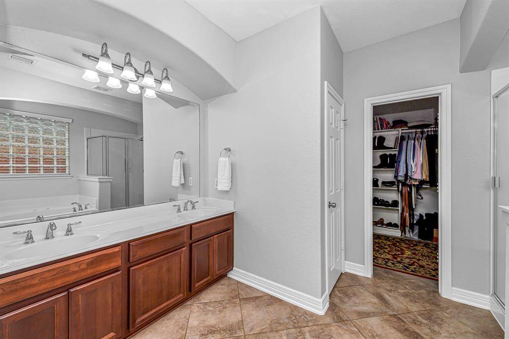 Primary en-suite bath featuring a soaking tub, enclosed shower and granite vanity.