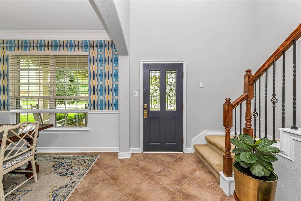 Spacious fenced backyard with a covered patio and plenty of green space for pets, play, or gardening. Brick exterior and mature landscaping offer privacy and durability.