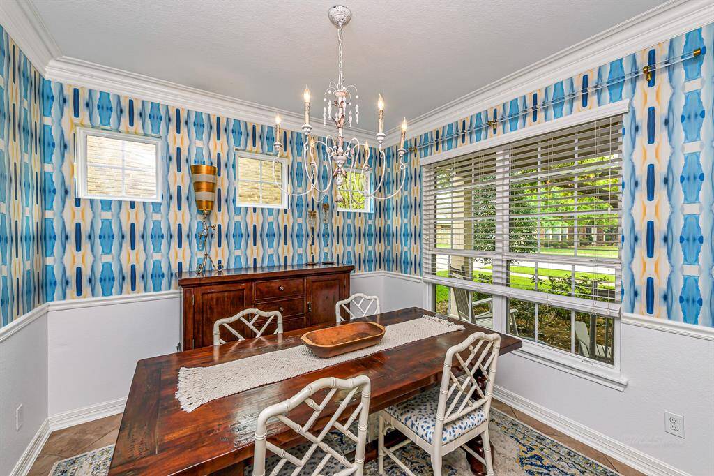 This formal dining room offers crown molding, large windows with custom blinds, and a bold accent wall that adds personality. It’s the perfect space for hosting dinners or holiday gatherings.