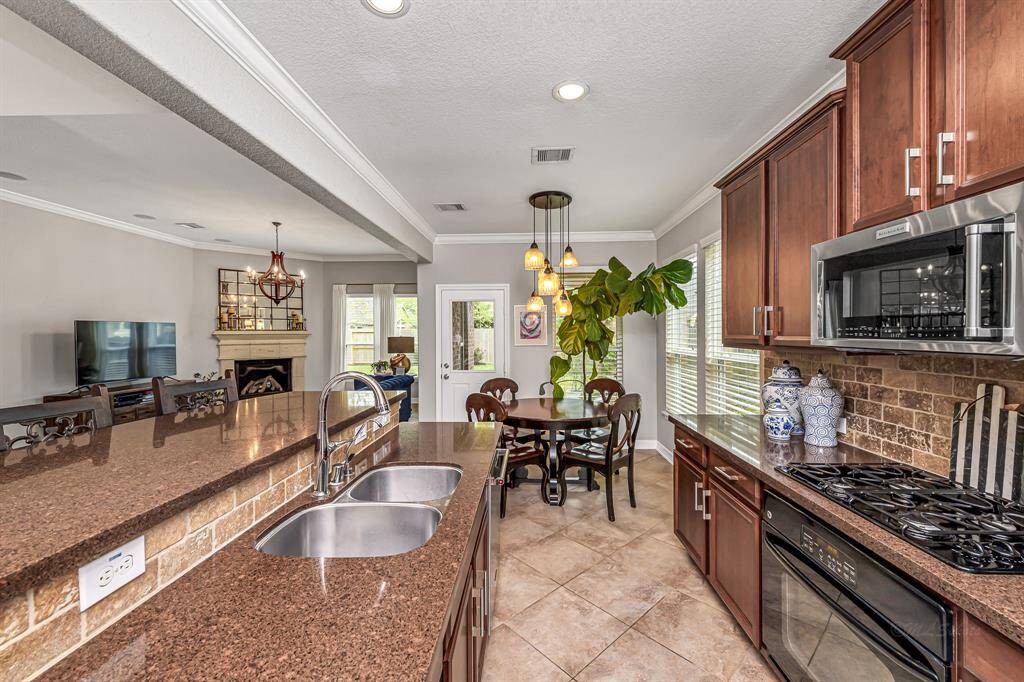 Bright and cozy, the breakfast nook features statement lighting, windows with custom blinds and backyard views. It connects seamlessly to the kitchen for easy meals and casual dining.