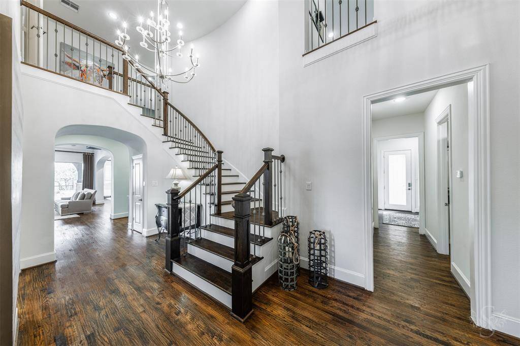 The magnificent grand entry showcases incredible style & design from the moment you walk in! Featuring a soaring ceiling with chandelier, formal dining room, study with double doors, curved staircase with wood risers and steps and decorative wrought iron balusters.