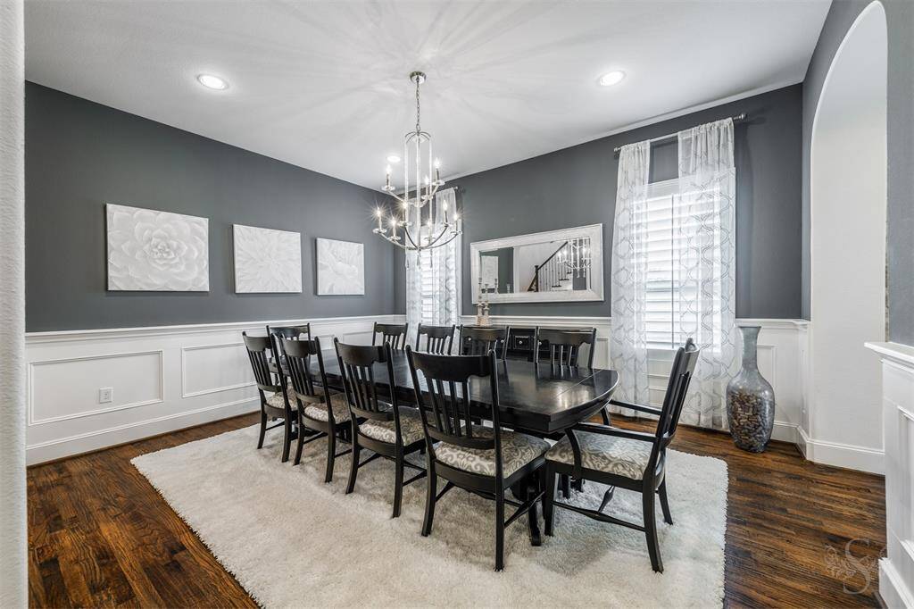 Enjoy having dinner parties in the formal dining room featuring wood flooring, high ceiling, contrasting chair railing, recessed lighting and chandelier and plenty of room for a large dining table and china cabinet!