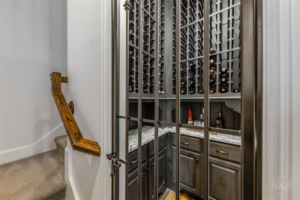 The wine grotto is tucked behind a decorative iron gate, creating a cozy, secure space for your wine collection. With plenty of bottle storage, a sleek granite countertop, and cabinetry below, it’s both functional and elegant for any wine enthusiast.