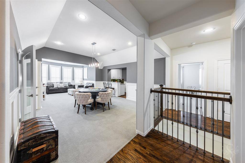 The lively game room features windows with plantation shutters that let in plenty of natural light, while the high angled ceiling with recessed lighting creates an open, airy feel. A convenient wet bar adds to the space, making it perfect for entertaining and enjoying games or snacks.
