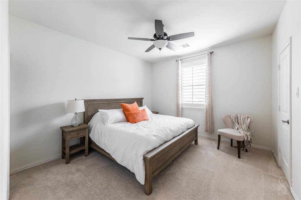 Secondary bedroom providing the space you need for a king bed and any additional furnishings needed including student desks and bookcases. Featuring a high ceiling, plush carpet for comfort and window with plantation shutters.