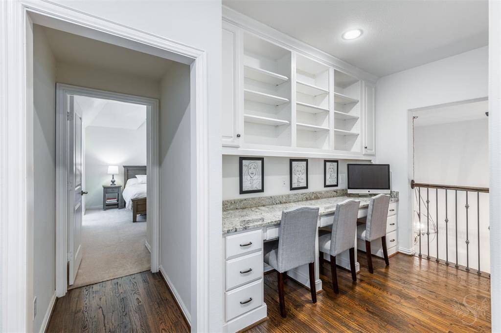A built-in study/computer station upstairs features a granite counter, offering plenty of space for work or study. With shelves above and drawers below, it provides convenient storage while keeping everything organized and within reach.