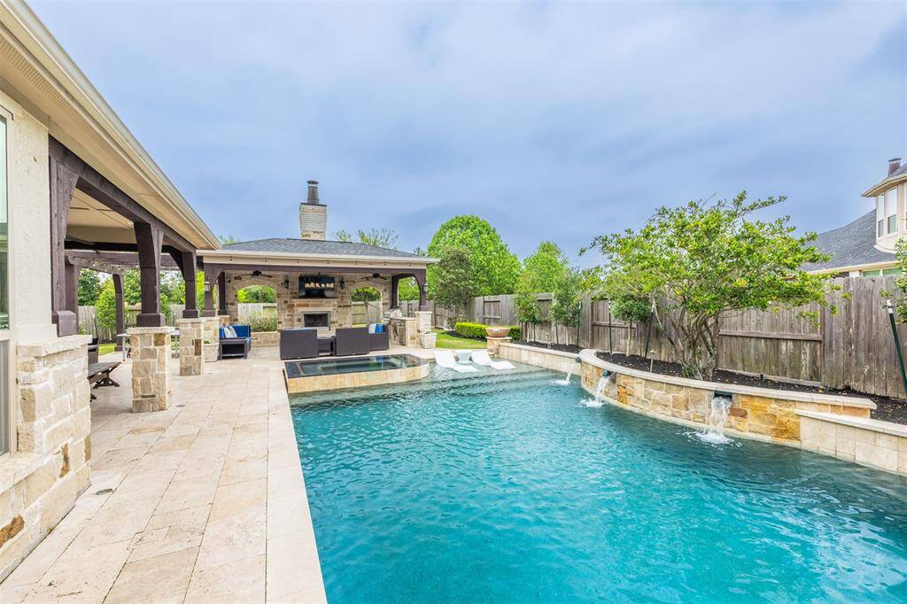 The two covered patios living areas, located beside the pool and spa, offer the perfect spaces for outdoor relaxation and entertainment. One features a cozy fireplace and an outdoor kitchen, making it ideal for cooking and enjoying evenings by the fire. Includes new pool heater.