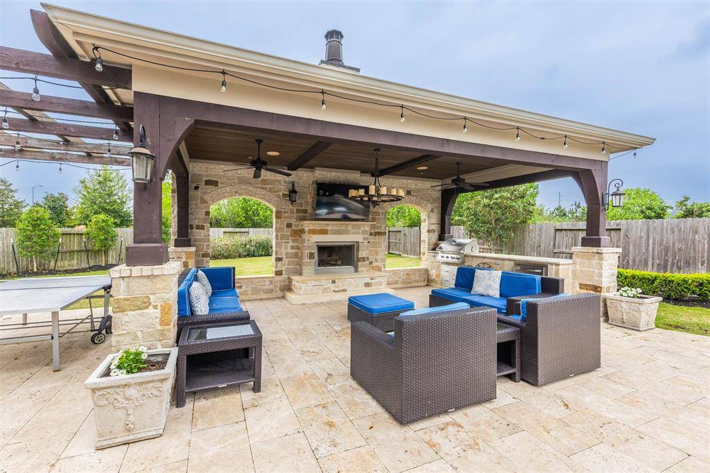 This covered patio is designed for comfort and style, featuring a cozy fireplace and a fully equipped outdoor kitchen for easy entertaining. With ceiling fans to keep the air cool, it’s the perfect spot to enjoy the outdoors year-round.