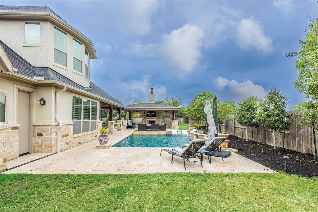 This outdoor living space offers a stunning view of the pool and spa, with two covered patios perfect for entertaining guests. The setup creates an ideal spot for relaxation and gatherings, blending comfort and style in a beautiful outdoor setting.