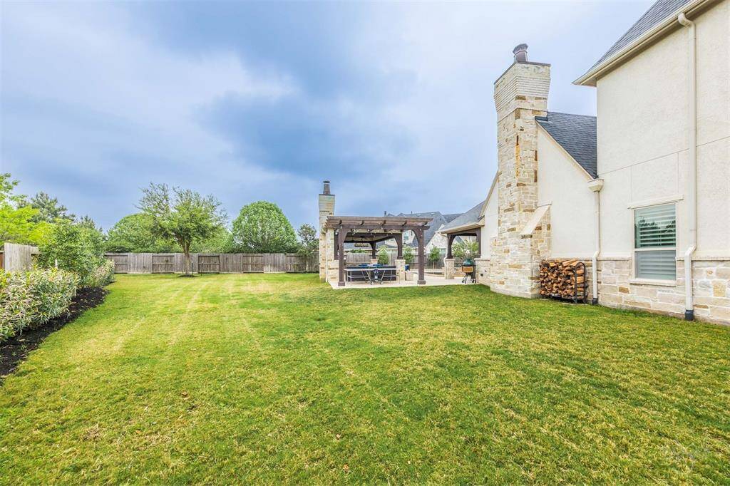 Large grassy backyard offers plenty of room for outdoor activities and entertainment, making it perfect for hosting gatherings or playing games. With its wide-open space, it provides a versatile area to enjoy the outdoors and make lasting memories.