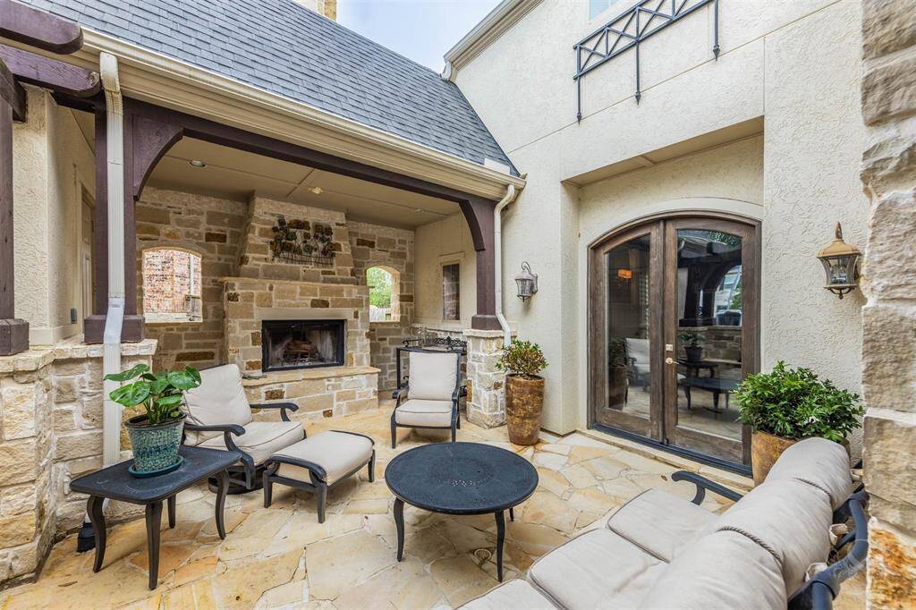 An elegant outdoor courtyard sets the stage for gatherings around a natural stone fireplace, offering a cozy and welcoming atmosphere. With plenty of space for comfortable seating, this outdoor area boasts  rustic elegance with relaxed comfort, creating the perfect spots to unwind or greet guests in style.